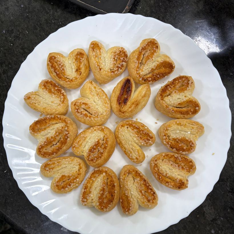 A white plate of heart-shaped sugar palmiers